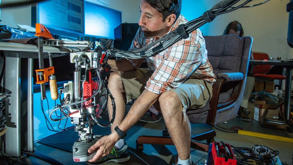 graduate student holding a robotic leg